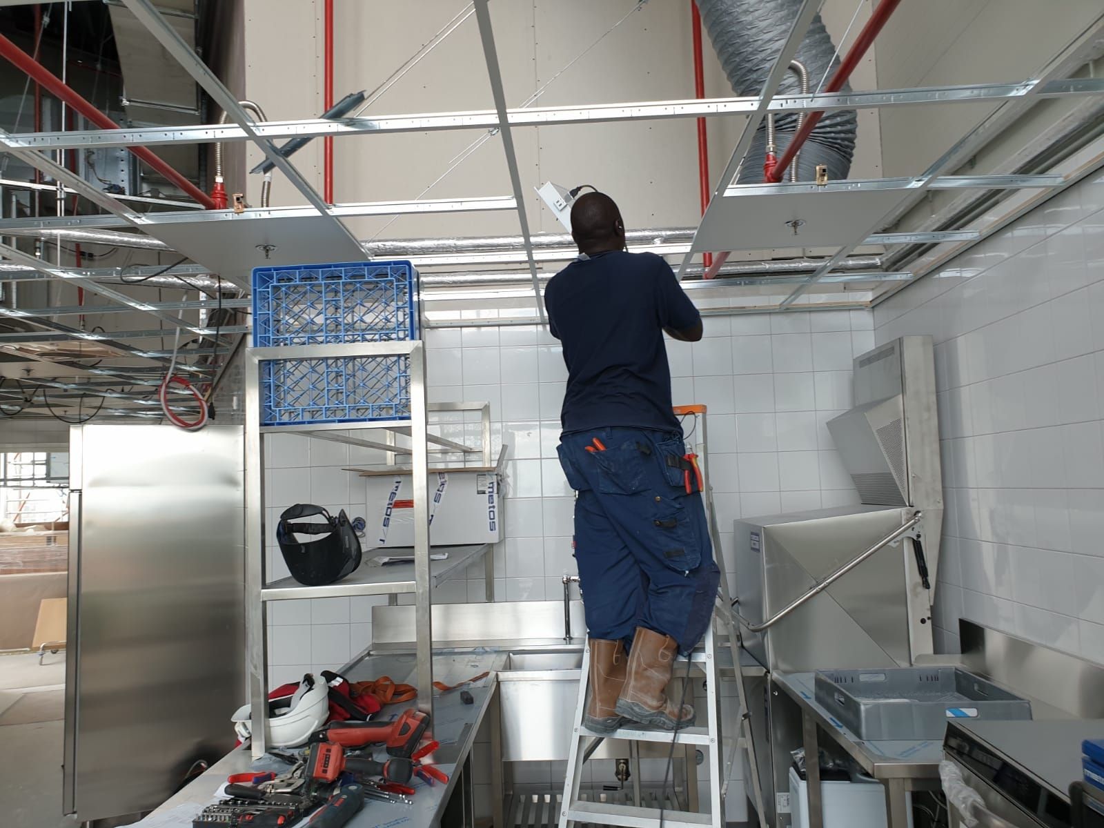 Technician installing ceiling electrical systems